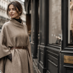 manteau poncho femme laine beige devant vitrine parisienne