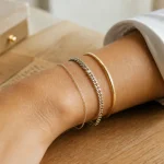Bracelets femme : chaîne fine, gourmette et jonc doré sur poignet